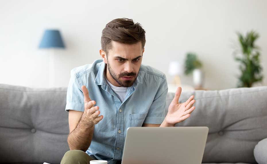 man frustrated on laptop